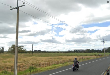 Image of a very flat landscape with a road and a motorcyclist on it.